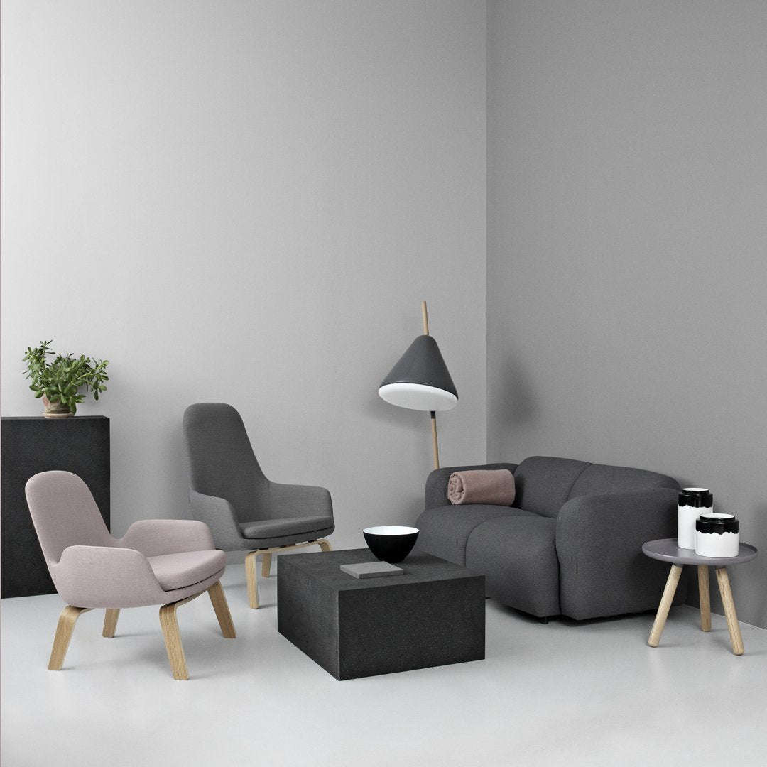 Modern living room set featuring gray and light pink furniture against a neutral gray backdrop, accented by natural wood.