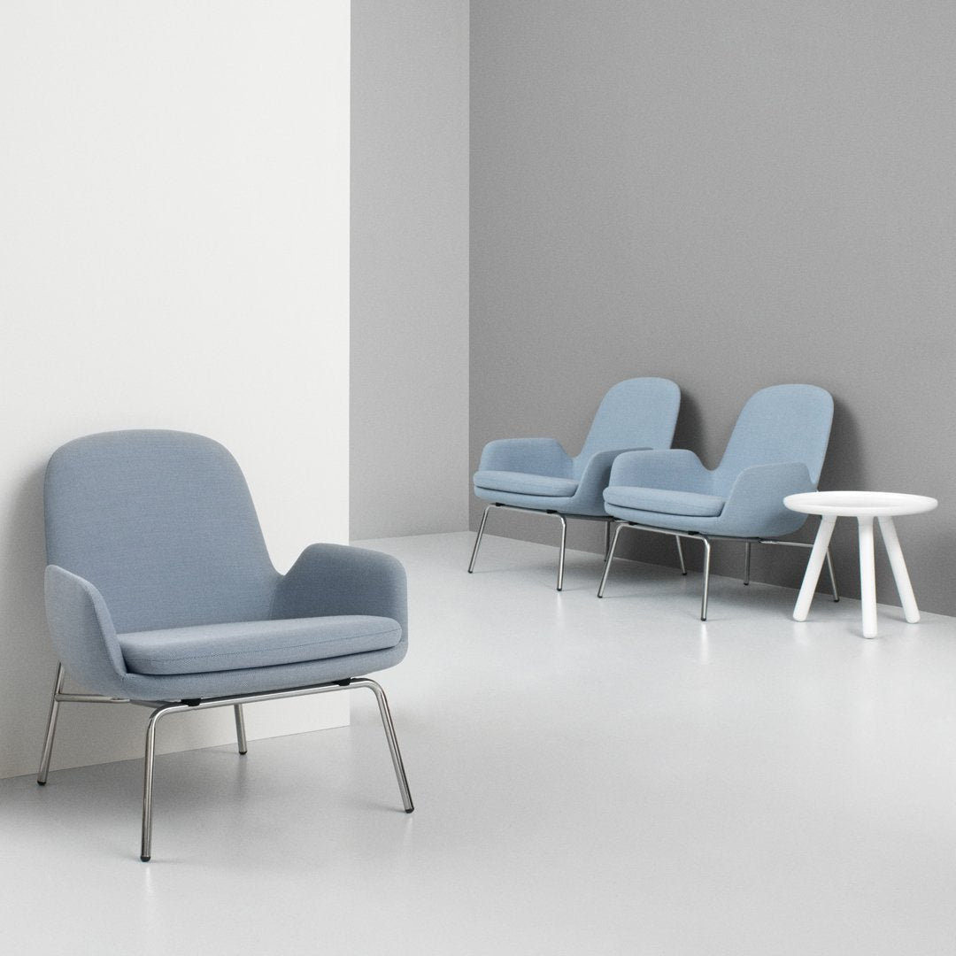 Soft blue upholstered armchairs with sleek metal legs against a minimalist gray and white background.