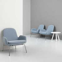 Soft blue upholstered armchairs with sleek metal legs against a minimalist gray and white background.