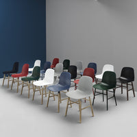 Colorful array of modern chairs in red, green, gray, white, and blue against a minimalist backdrop.