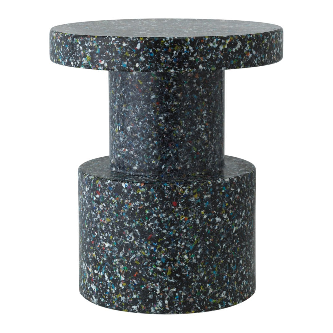 Dark speckled surface with colorful flecks, showcasing a modern, minimalist cylindrical design. Ideal for contemporary spaces.