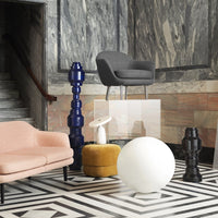 Modern furniture with gray, pink, yellow, and blue tones on a black and white geometric floor pattern.
