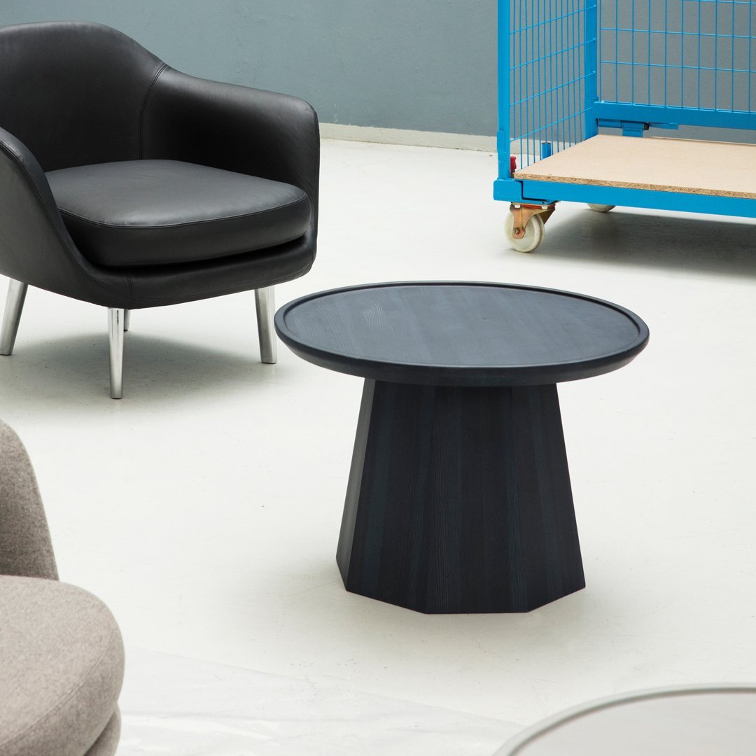 Modern round black coffee table with a textured, geometric base and a smooth circular top. Ideal for contemporary decor.