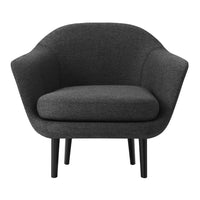 Gray upholstered armchair with a minimalist design and smooth, rounded contours, supported by black wooden legs.