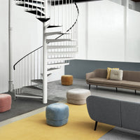 Colorful poufs in pink, blue, yellow, and tan enhance a modern living space with a stylish gray sofa and patterned rug.