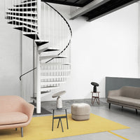 Soft pink, muted gray, and vibrant yellow accents on modern furniture with a minimalist design.