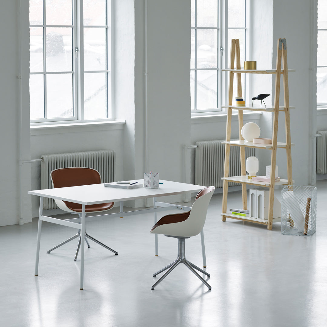 "Modern white desk with wooden accents and brown chair, featuring soft colors in a bright, minimalist setting."