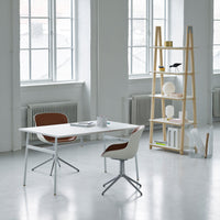 "Modern white desk with wooden accents and brown chair, featuring soft colors in a bright, minimalist setting."