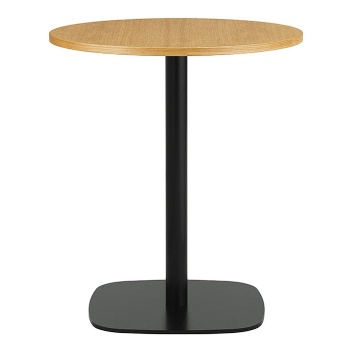 Round wooden table with a light oak finish atop a sleek black metal base. Simple, modern design with no patterns.