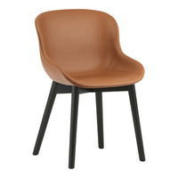 Tan leather chair with a smooth finish and black wooden legs, featuring a modern, minimalist design.