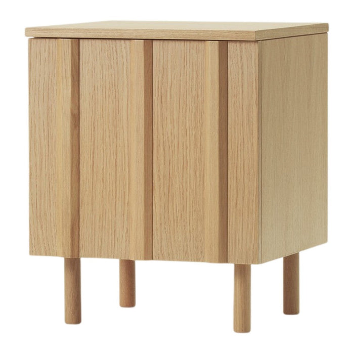 Light oak wood nightstand with vertical slats, natural finish, minimalist design, and tapered legs.
