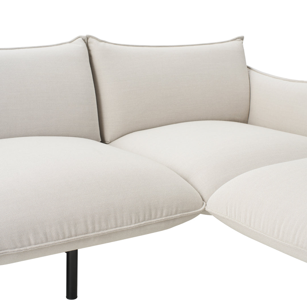 Cream-colored fabric sectional sofa with soft, smooth cushions and minimalist design. Perfect for modern interiors.