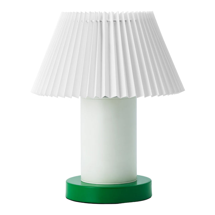 White pleated lamp shade atop a frosted glass base with a vibrant green circular bottom.