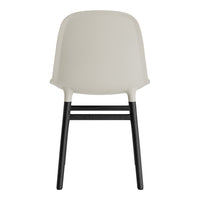 Minimalist chair in soft beige with sleek black wooden legs, showcasing a modern design and clean lines.