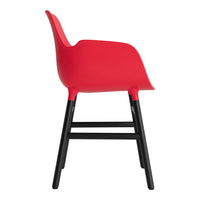 Red chair with a smooth finish and sleek black legs, featuring a modern design and minimalist curves.