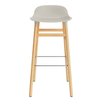 Gray plastic stool with natural wood legs and a silver footrest, featuring a smooth, minimalist design.