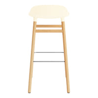 Cream-colored seat with light wooden legs and a silver footrest, featuring a minimalist design.