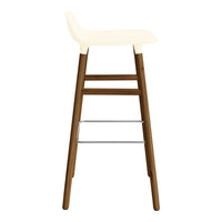 Cream bar stool with a minimalist design, featuring a smooth seat and dark wood legs contrasted by silver accents.