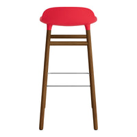 Red upholstered bar stool with a sleek wooden base and silver footrest. Modern design, vibrant color pops.