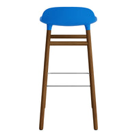 Blue plastic seat with natural wood legs and silver footrest, modern design. Perfect for stylish interiors.