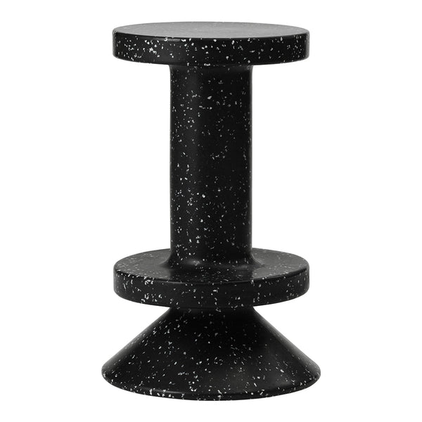 Black stool with a speckled white pattern, featuring a modern design with a circular top and conical base.