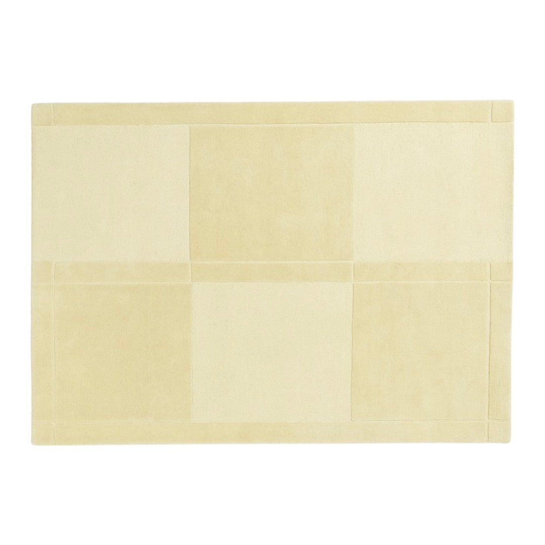 Beige area rug with a subtle patchwork pattern, featuring soft, light tones for a warm and inviting look.