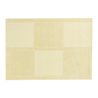 Beige area rug with a subtle patchwork pattern, featuring soft, light tones for a warm and inviting look.
