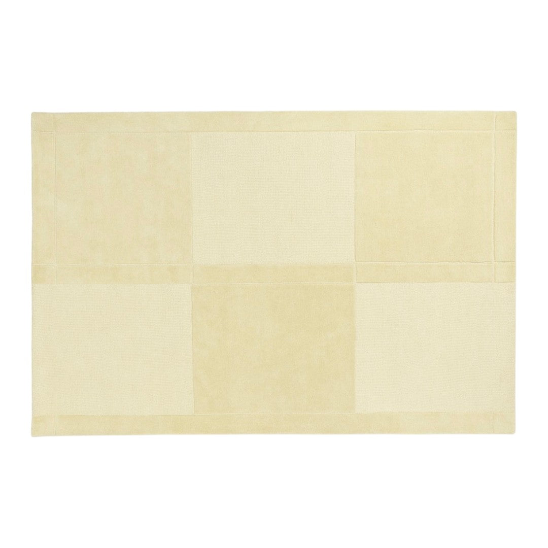 beige patchwork rug with soft texture and subtle tonal variations in shades of cream and off-white.