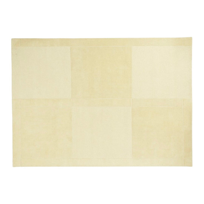 Beige rug featuring a subtle patchwork pattern with varying textures and shades of cream. Ideal for modern decor.