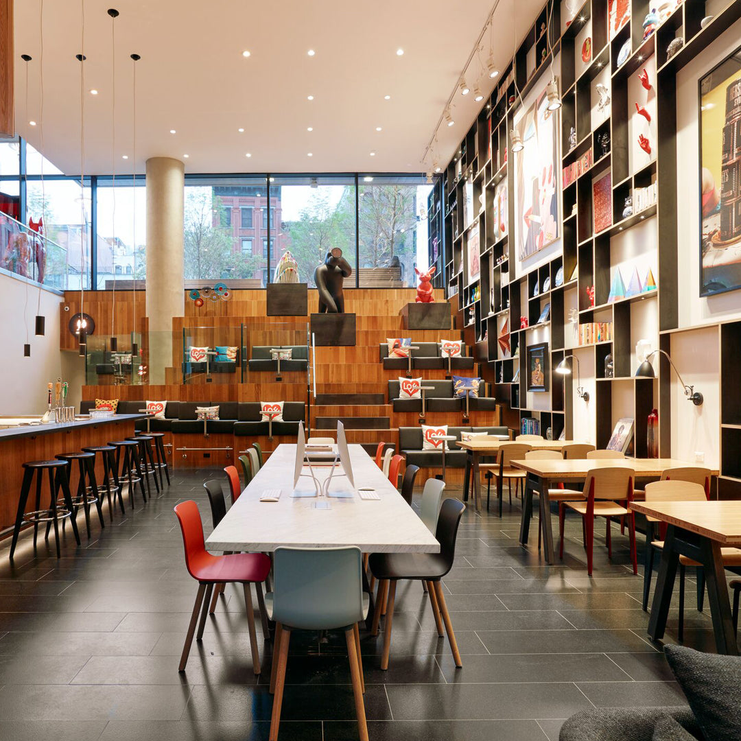 Colorful chairs in red, blue, and beige with a modern wooden and black patterned decor in a stylish interior setting.