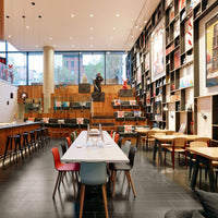 Colorful chairs in red, blue, and beige with a modern wooden and black patterned decor in a stylish interior setting.