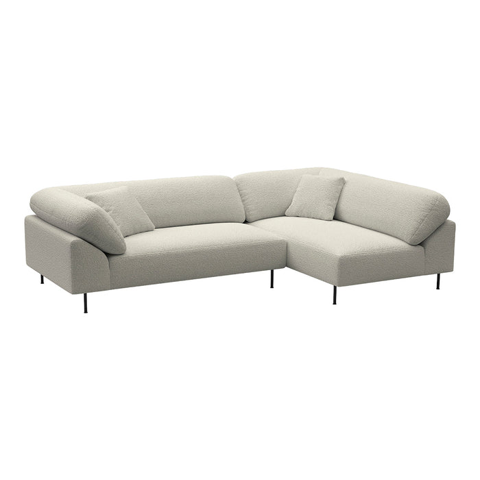 Light beige sectional sofa with soft fabric and minimalist design, featuring smooth textures and subtle accent pillows.