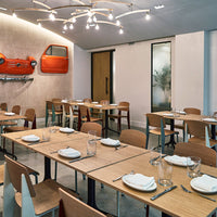 Modern restaurant interior featuring a mix of natural wood tones and vibrant orange accents. Sleek, minimalist design.