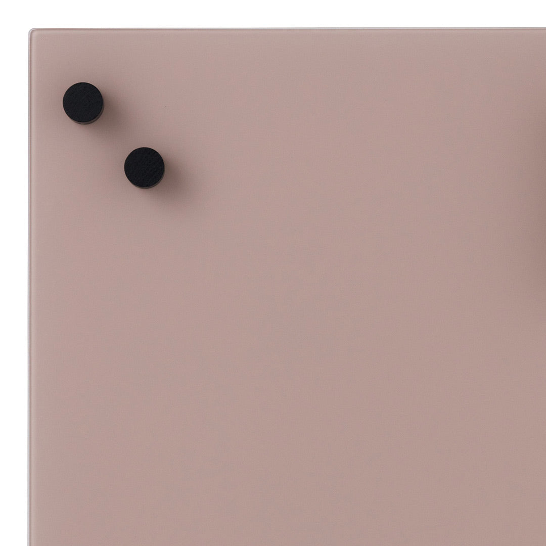 Soft pink surface with two black round knobs, creating a minimalist and modern look. Perfect for contemporary decor.