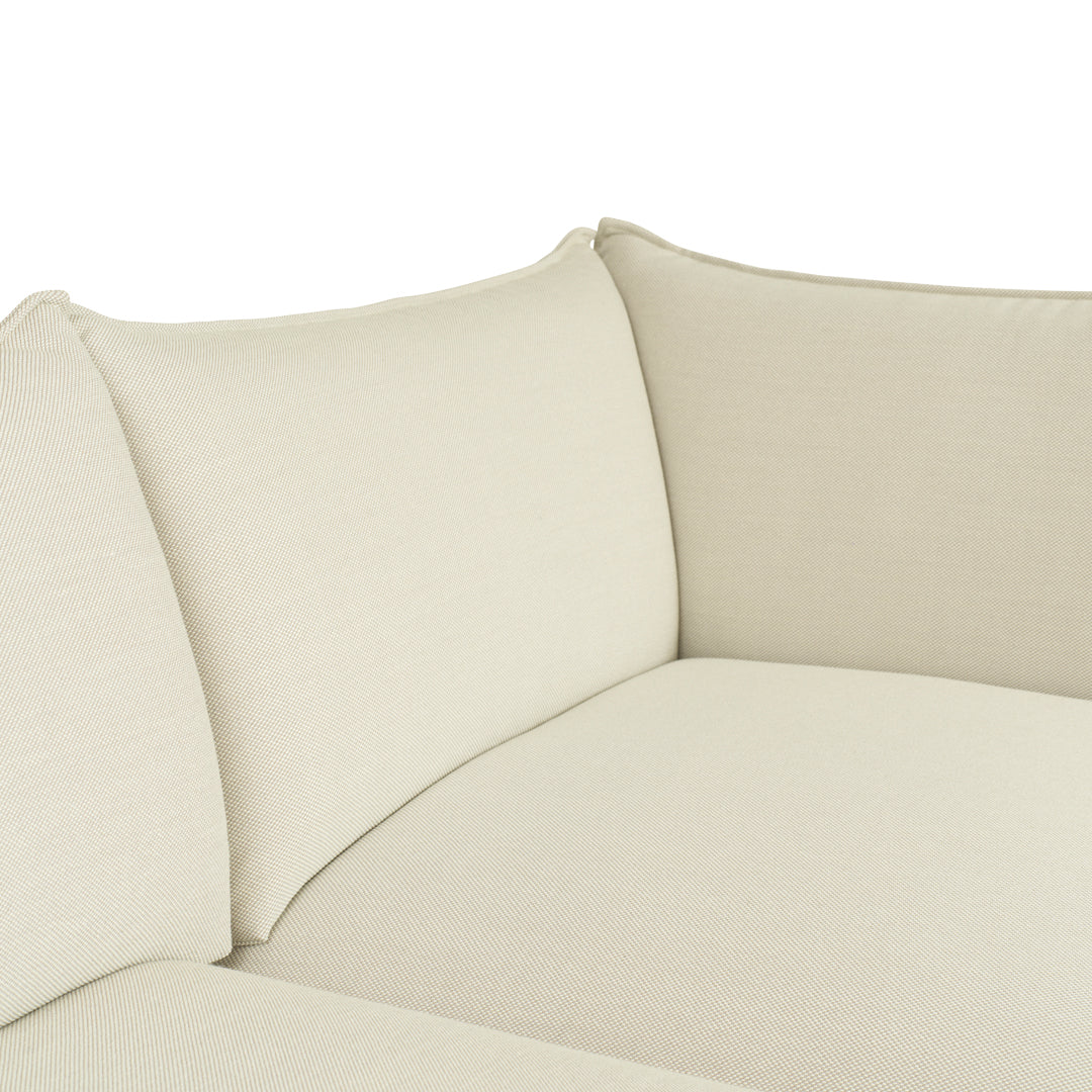 Beige fabric sectional sofa with textured, solid-color upholstery for a modern and minimalist look.