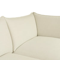 Beige fabric sectional sofa with textured, solid-color upholstery for a modern and minimalist look.