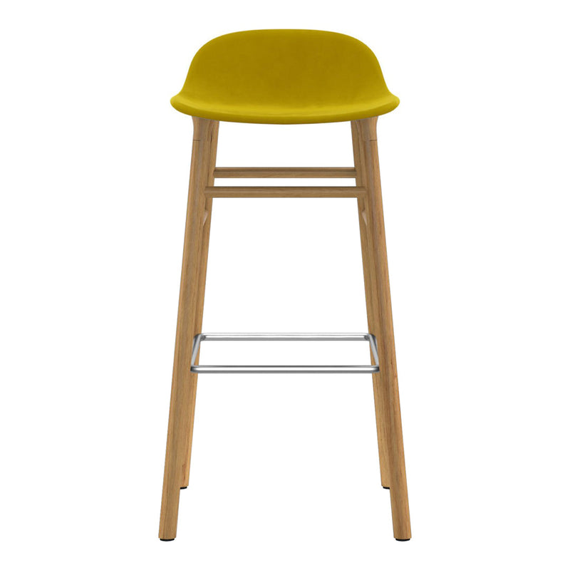 Yellow upholstered bar stool with natural wood legs and a metallic footrest, showcasing a modern, minimalist design.