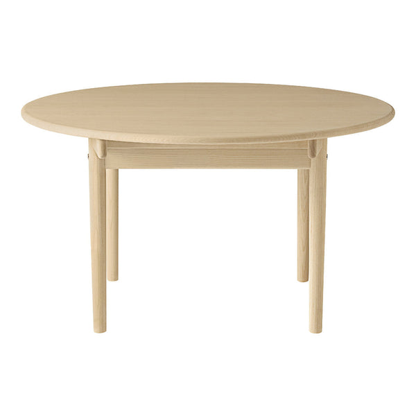 Round wooden table in a light beige finish with a smooth, minimalist design. Perfect for modern dining spaces.
