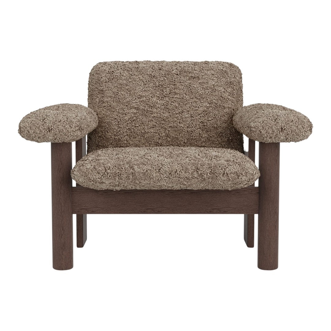 Brown textured armchair with soft, shaggy upholstery and dark wooden frame. Cozy and inviting design.
