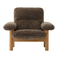 Brown textured armchair with plush fabric and wooden frame, featuring soft, rounded armrests for comfort.