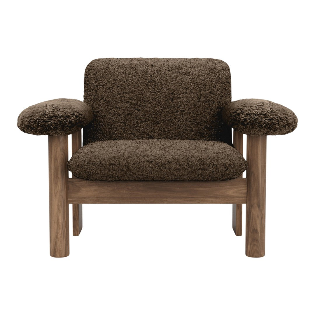 Brown textured fabric armchair with wooden legs, featuring a cozy and stylish design. Perfect for modern interiors.