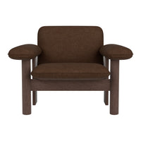 Brown upholstered chair with smooth, rounded arms and a minimalist design. Elegant neutral tones for versatile decor.