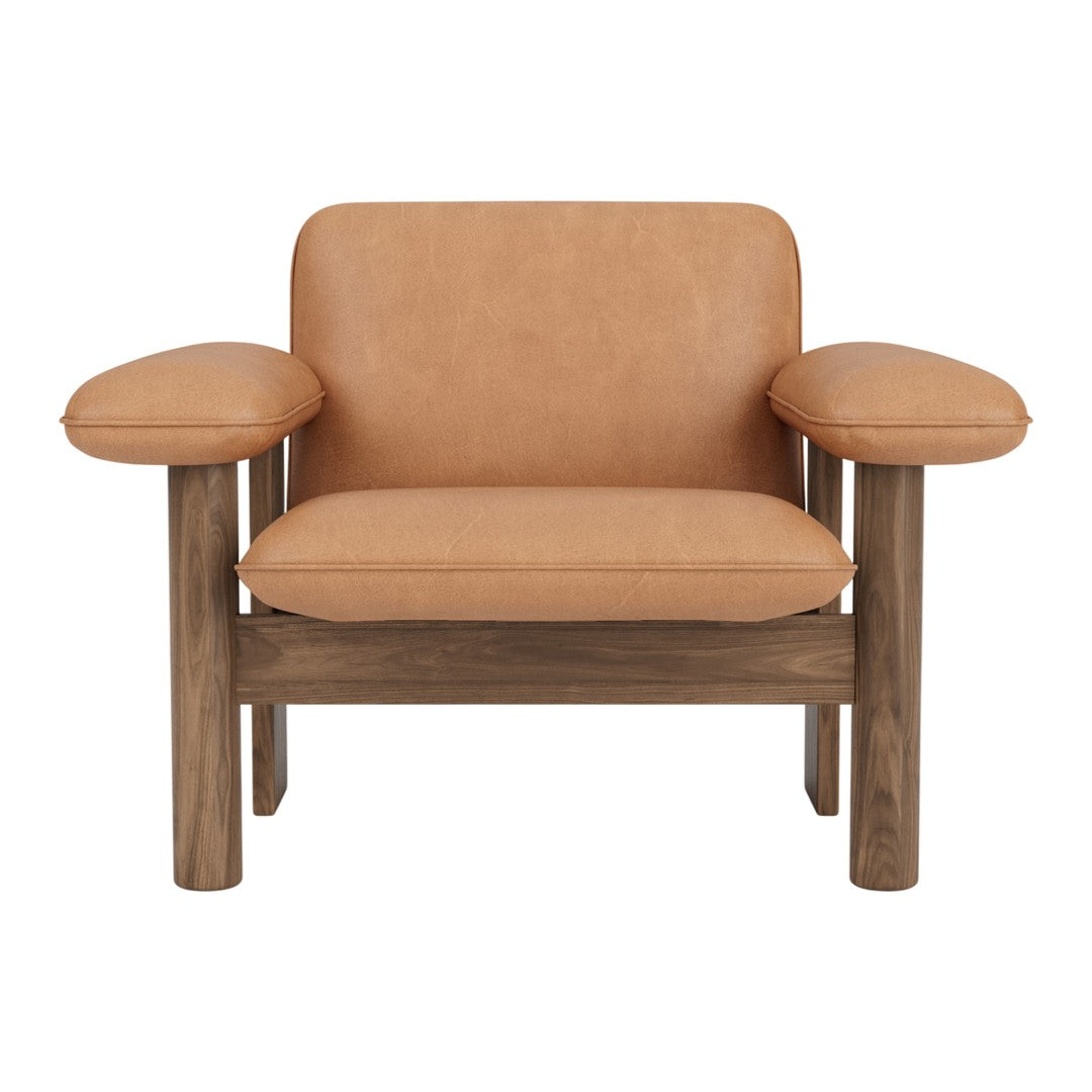 Tan leather armchair with smooth finish and light wooden legs, featuring simple, modern design and rounded armrests.