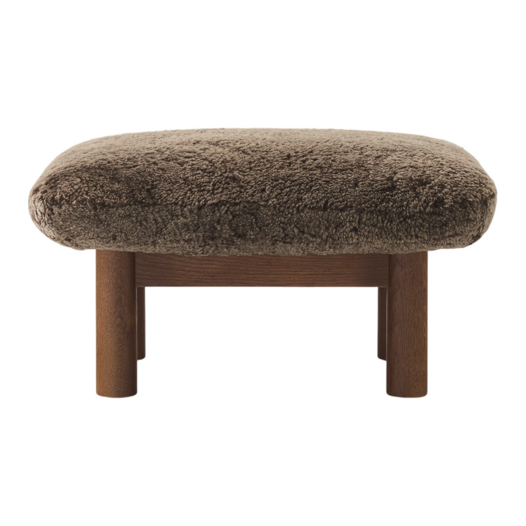 Brown plush ottoman with textured upholstery and wooden legs, perfect for adding warmth to any space.