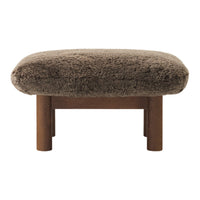 Brown plush ottoman with textured upholstery and wooden legs, perfect for adding warmth to any space.