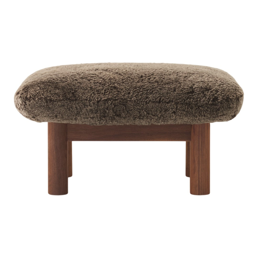Cozy brown faux fur ottoman with wooden legs, perfect for modern decor. Soft texture and rich color enhance any space.