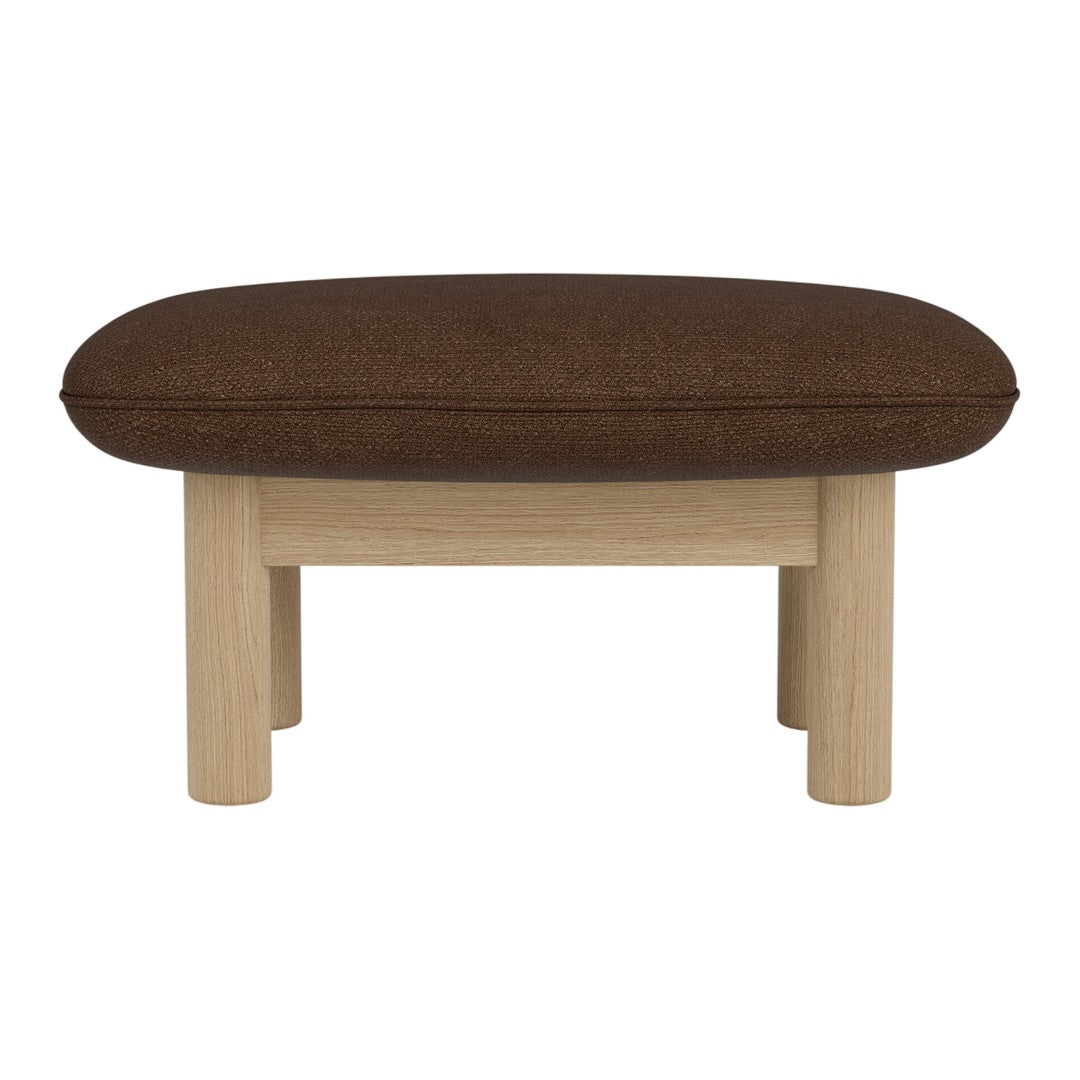 Brown upholstered ottoman with a smooth oval shape and light wooden legs. Minimalist design for versatile decor.
