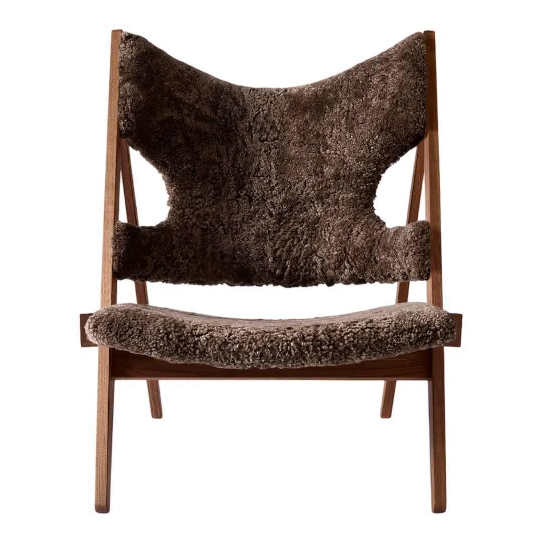 Brown upholstered chair with a unique, textured pattern and minimalist wooden frame. Stylish and cozy design.