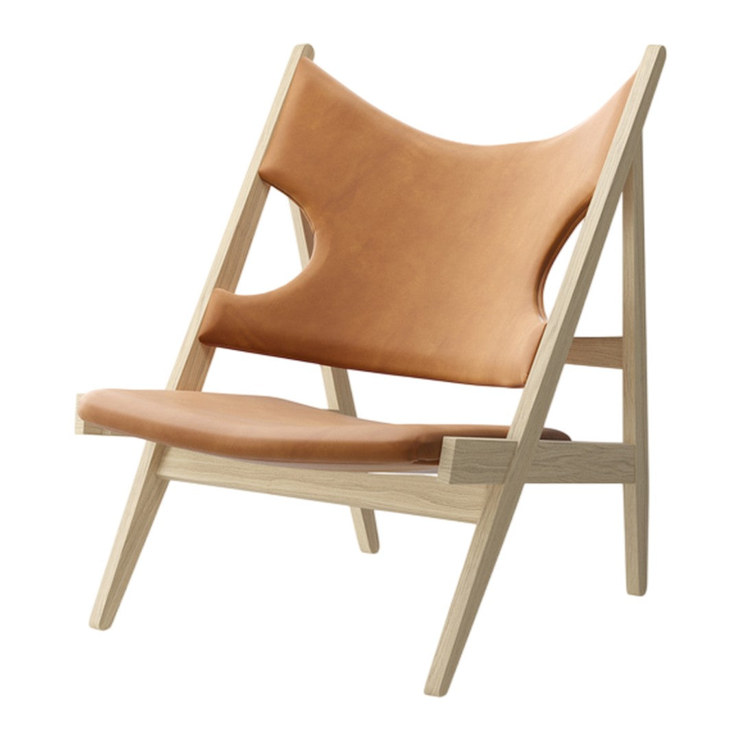 Tan leather lounge chair with minimalist wood frame, featuring smooth surfaces and clean lines for a modern look.