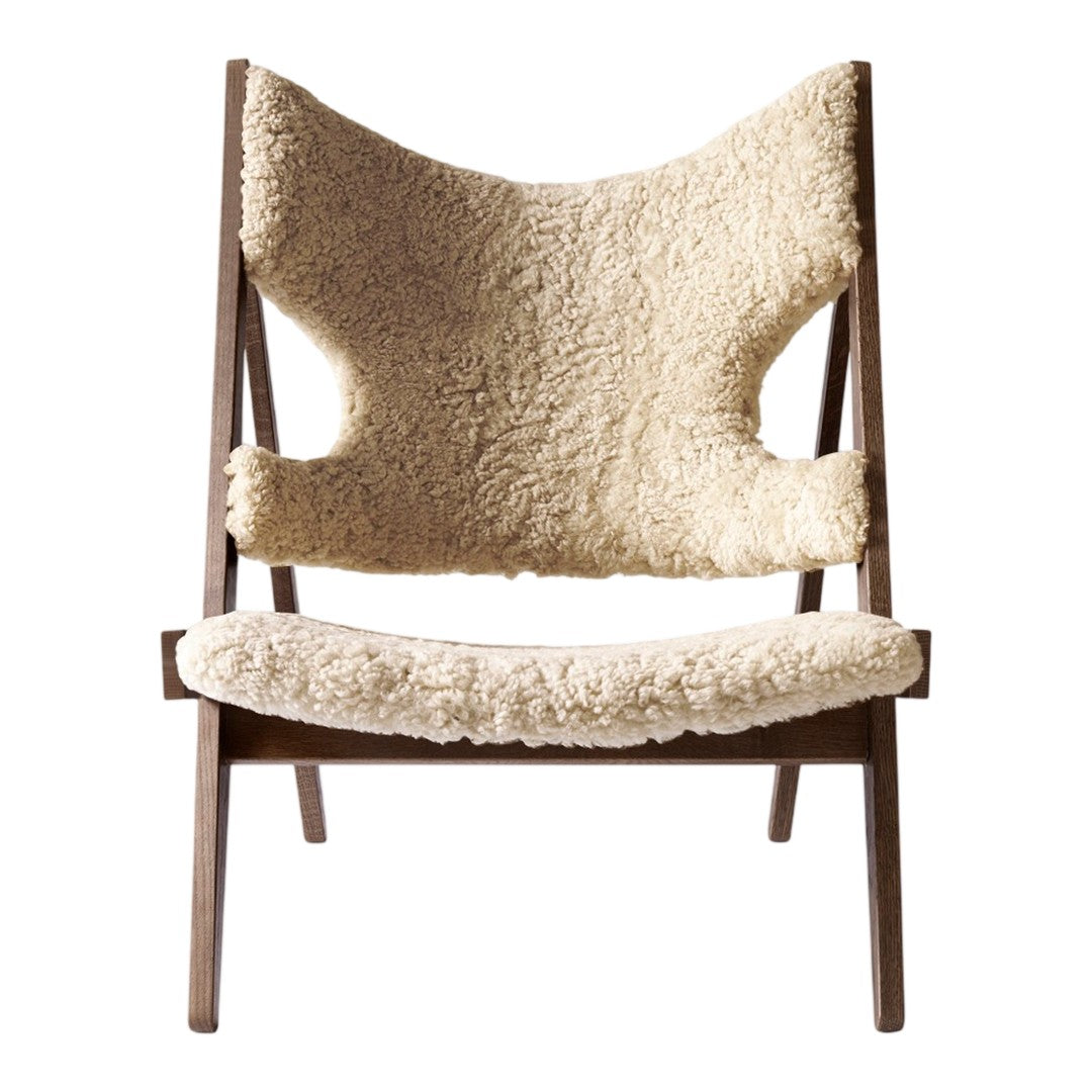 Beige sheep wool upholstery on a minimalist wooden chair with clean lines and a modern design.
